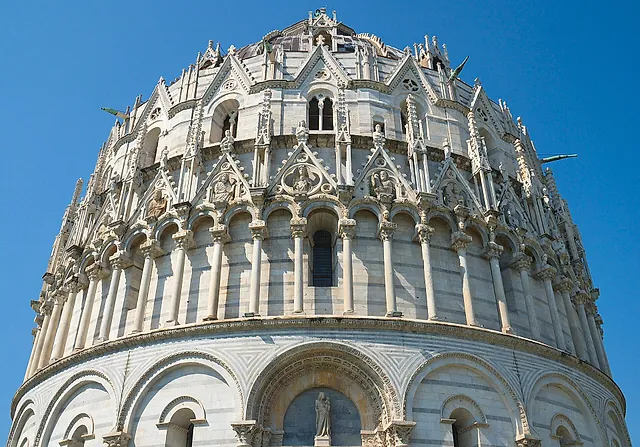 Particolare del Battistero di Pisa visto dal basso: i piani di arcate e i pinnacoli gotici sopra il portale principale