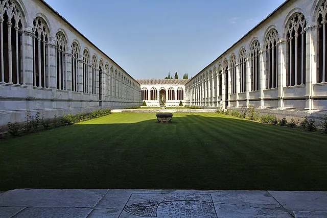 Le lunghe arcate di marmo bianco del Camposanto Monumentale ai due lati del cortile erboso